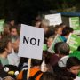 Demonstranten zeigen Plakate mit der Aufschrift No!